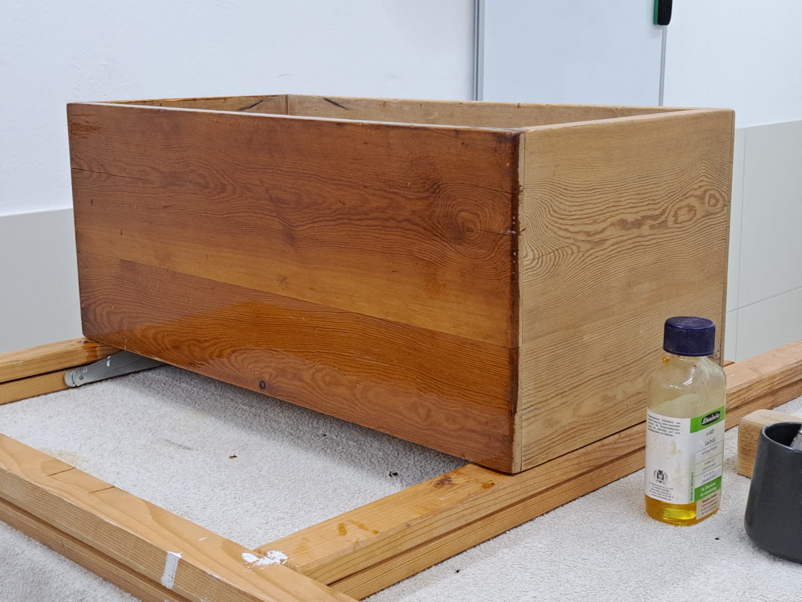 Aplicando aceite protector con brocha sobre una superficie de madera