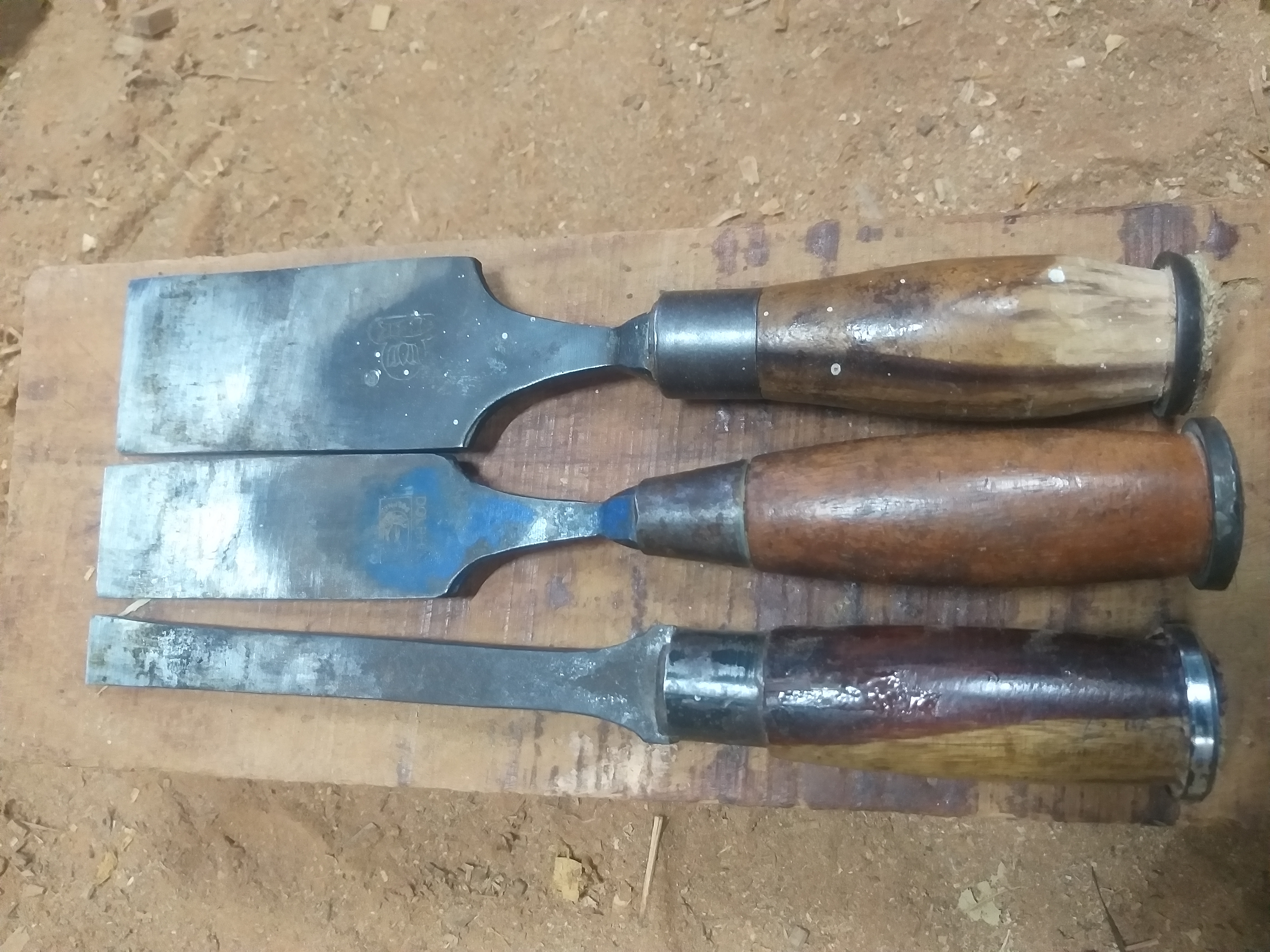 Juego de formones de carpintero con mangos de madera sobre un banco de trabajo