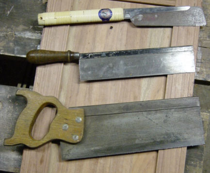 Tres serruchos de espalda de diferentes tipos apoyados uno junto a otro